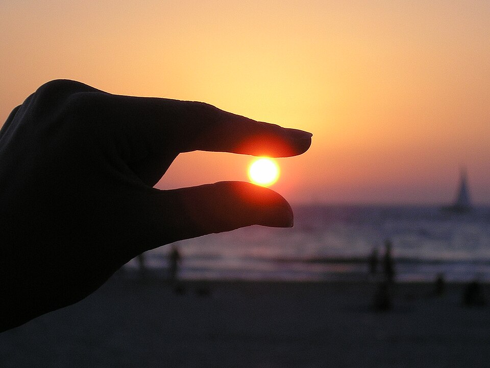 Holds the sun in her fingers